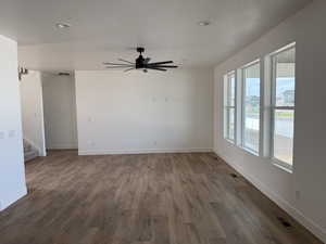 Unfurnished room featuring dark wood-style floors, ceiling fan, and a textured ceiling