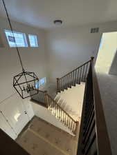 Staircase with a high ceiling and a chandelier