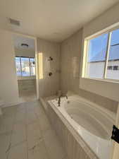 Bathroom with a garden tub and a tile shower