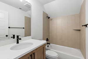 Bathroom with vanity, bathing tub / shower combination, and lofted ceiling