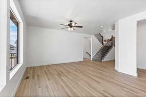 Unfurnished living room featuring light wood finished floors and a ceiling fan
