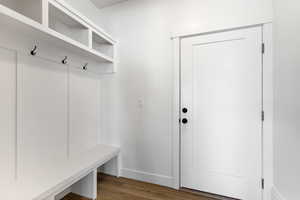 Mudroom featuring dark wood-style flooring and baseboards
