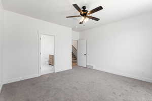 Unfurnished bedroom featuring carpet flooring, a ceiling fan, and ensuite bathroom