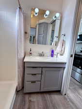 Bathroom featuring dark wood-type flooring, a stall shower, and vanity