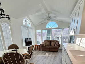 Sunroom featuring lofted ceiling and a sink