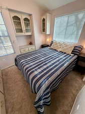 Carpeted bedroom featuring vaulted ceiling