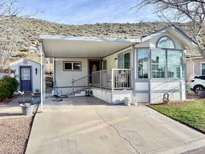 Manufactured / mobile home featuring a shed, a patio area, and an attached carport