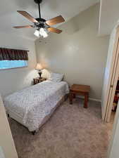 Bedroom with carpet flooring, ceiling fan, and vaulted ceiling