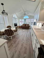 Sunroom / solarium featuring vaulted ceiling, wood finished floors, and plenty of natural light