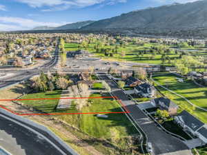 Aerial perspective of suburban area featuring property boundaries highlighted and a mountain backdrop