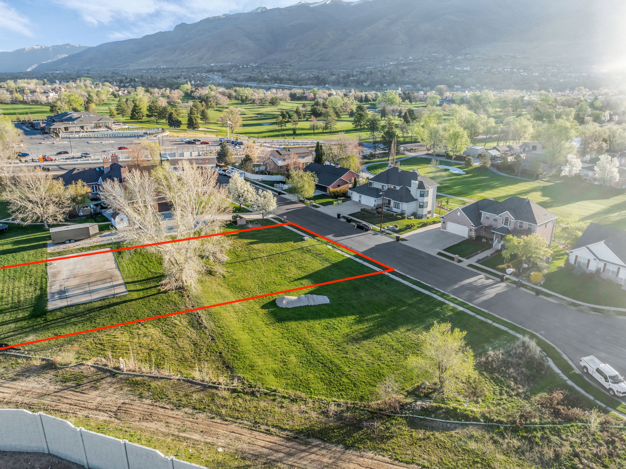 Aerial view of residential area featuring property parcel outlined and a mountain backdrop