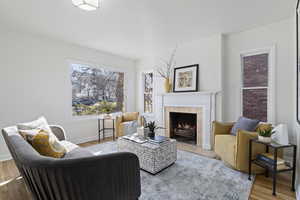 Living area with hardwood / wood-style floors and a tiled fireplace
