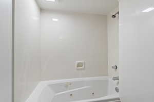 Full bath featuring a combined bath / shower with jetted tub
