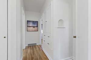 Hall with light wood-style flooring and baseboards