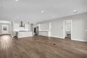 Unfurnished living room with dark wood finished floors and recessed lighting