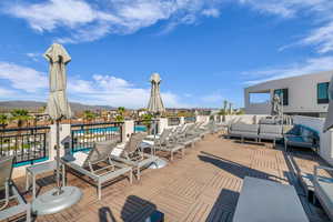 Wooden deck with outdoor seating and a community pool