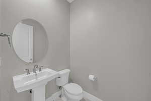 Half bath with toilet and baseboards