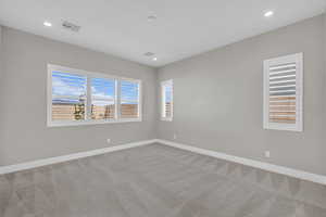 Empty room featuring light colored carpet and recessed lighting