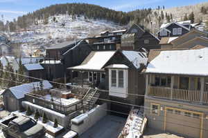 Snowy aerial view with a mountain view and a residential view