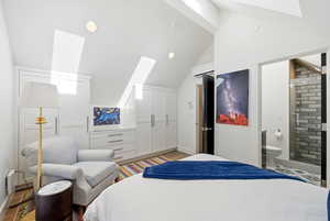 Bedroom featuring a skylight, wood finished floors, vaulted ceiling, and recessed lighting
