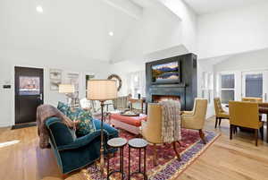 Living area featuring light wood-style floors, a large fireplace, recessed lighting, and plenty of natural light