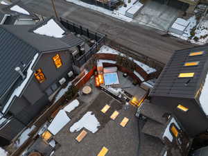 Snowy aerial view with view of pool