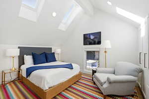 Bedroom featuring a skylight and beam ceiling