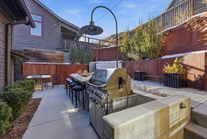 Fenced backyard with exterior kitchen and a patio