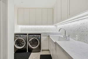 Laundry room featuring cabinet space, washing machine and clothes dryer, and light tile patterned floors