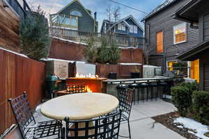 Fenced backyard featuring a patio, exterior kitchen, and an outdoor bar and dining area
