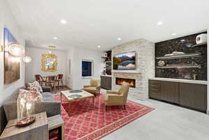 Living area featuring a stone fireplace, recessed lighting, and light tile patterned floors