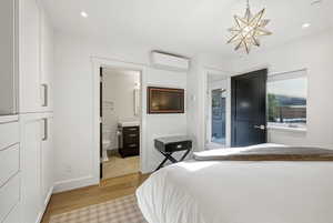 Bedroom featuring light wood-style flooring, access to outside, recessed lighting, and ensuite bath