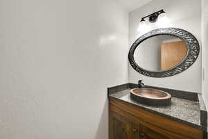 Bathroom featuring vanity and a textured wall