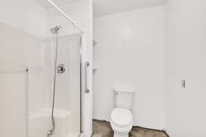 Bathroom with a shower stall and concrete floors