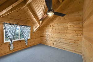 Additional living space with carpet floors, wooden walls, and wooden ceiling