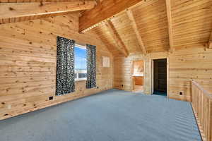 Bonus room with a wood ceiling with exposed beams, carpet, wooden walls, and high vaulted ceiling