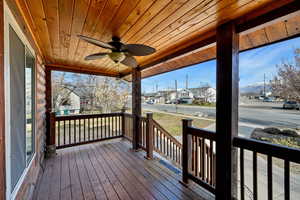 Wooden porch featuring a ceiling fan and a residential view