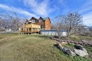 Back of property featuring a covered pool and a wooden deck