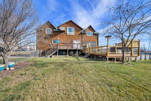 Back of property with a deck, a fenced backyard, and stairway