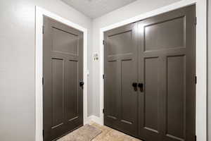 Foyer featuring a textured ceiling and baseboards