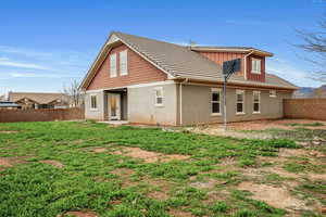 Back of house with a fenced backyard and stucco siding