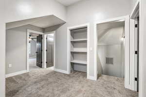 Unfurnished bedroom with light colored carpet and a closet