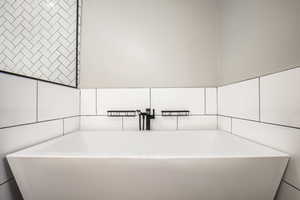 Bathroom featuring a bath and tile walls
