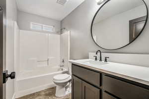 Full bathroom featuring vanity, tub / shower combination, and a textured ceiling
