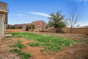 Fenced backyard featuring a mountain view