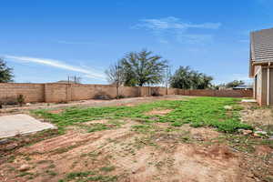 Fenced backyard with a patio area