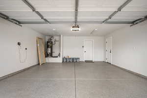 Garage featuring secured water heater and a garage door opener