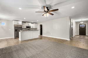 Unfurnished living room featuring light tile patterned flooring, a textured ceiling, recessed lighting, light carpet, and a ceiling fan
