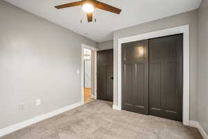 Unfurnished bedroom with a closet, carpet flooring, and ceiling fan