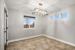 Unfurnished dining area featuring a textured ceiling and a chandelier